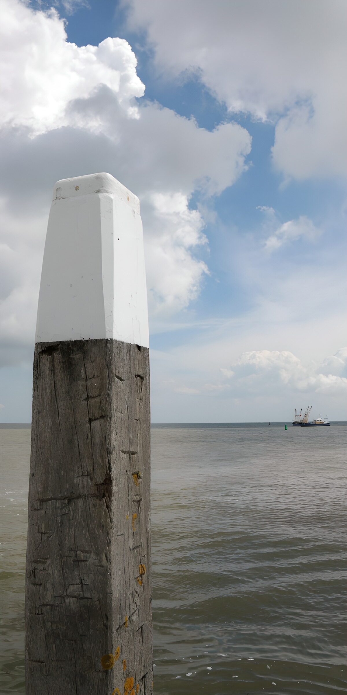 Houten paal bij de zee