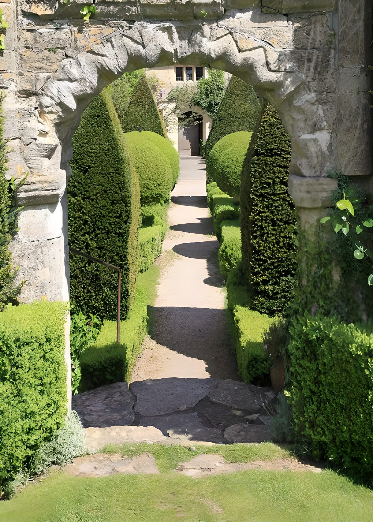 Prachtige tuinpoort met groene hagen