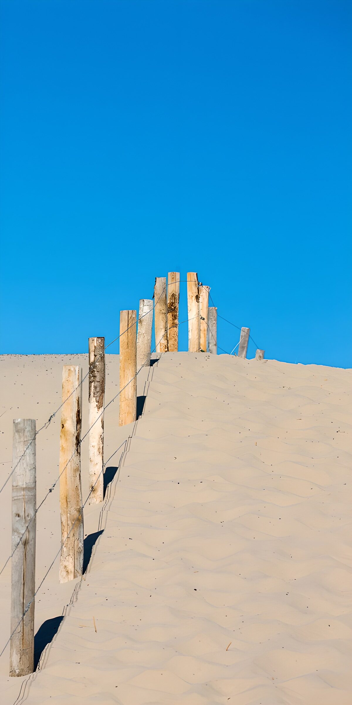 Houten palen langs de zandweg