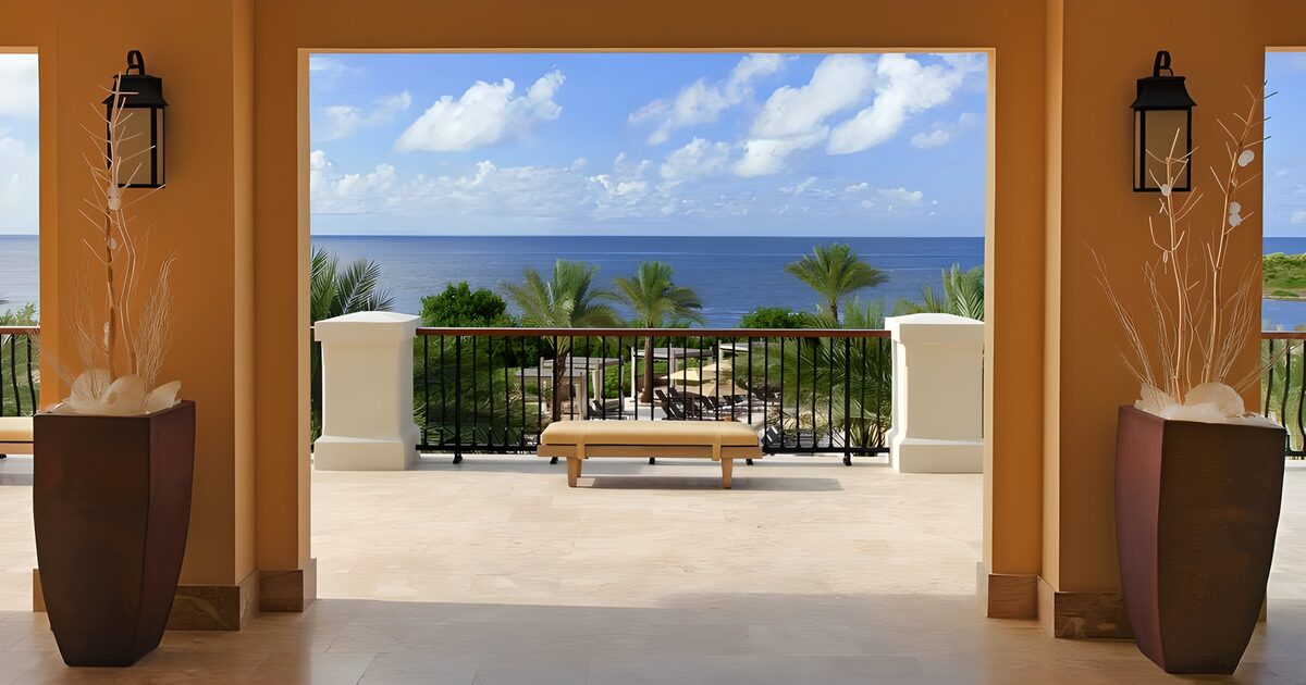 Doorkijk vanuit resort op palmbomen en de Caribische zee