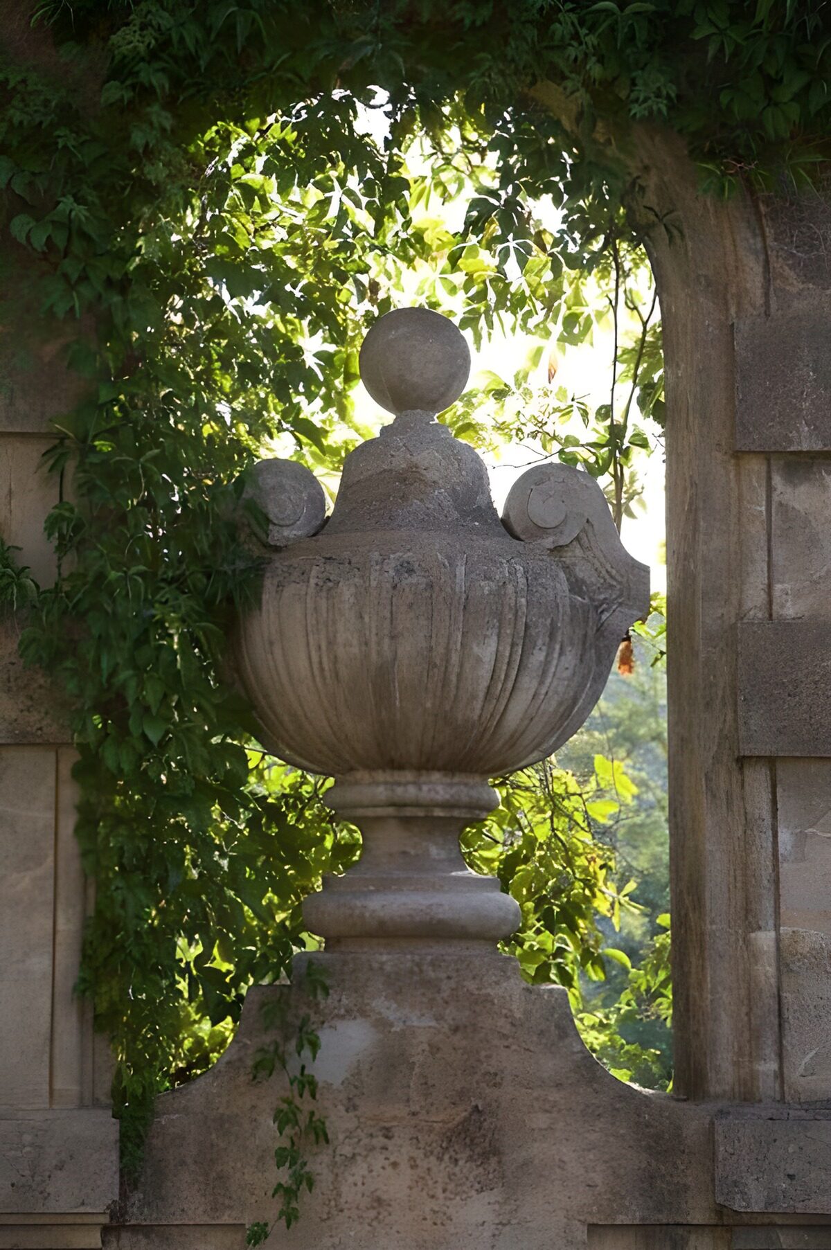 TP52412: Beeld van een urn in venster van boog met klimop