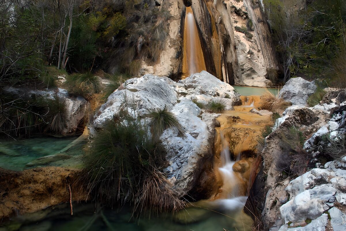 Waterval tussen rotsen en helder water