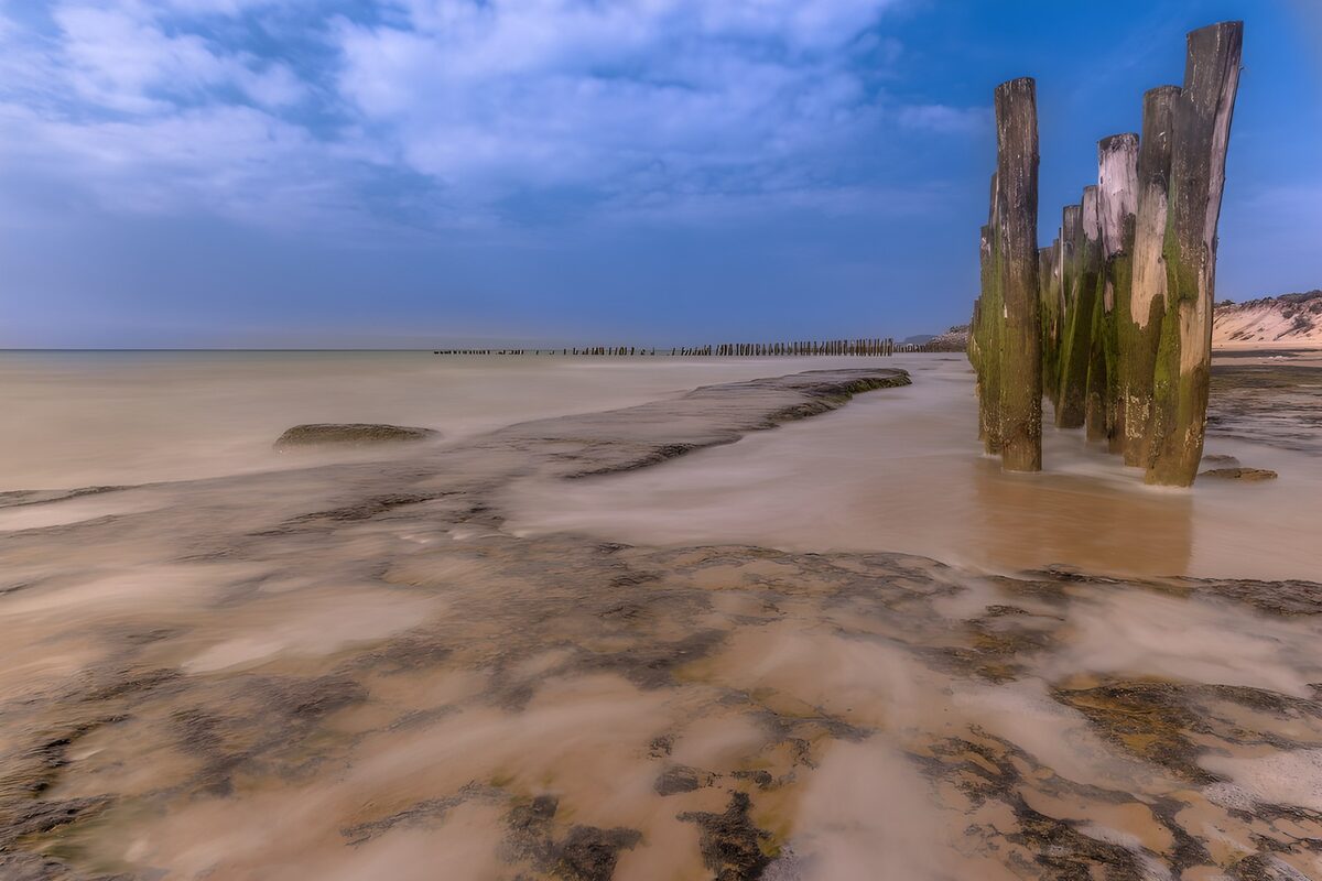 TP89123: Rustige zeestrand met oude palen