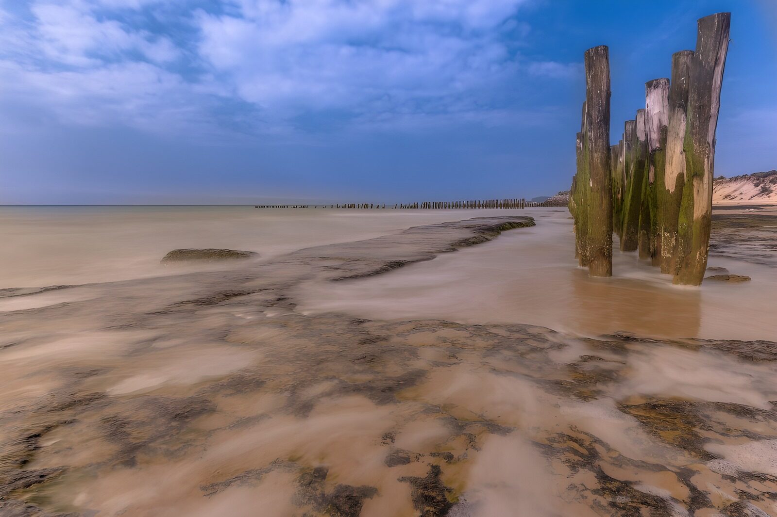 TP89123: Rustige zeestrand met oude palen