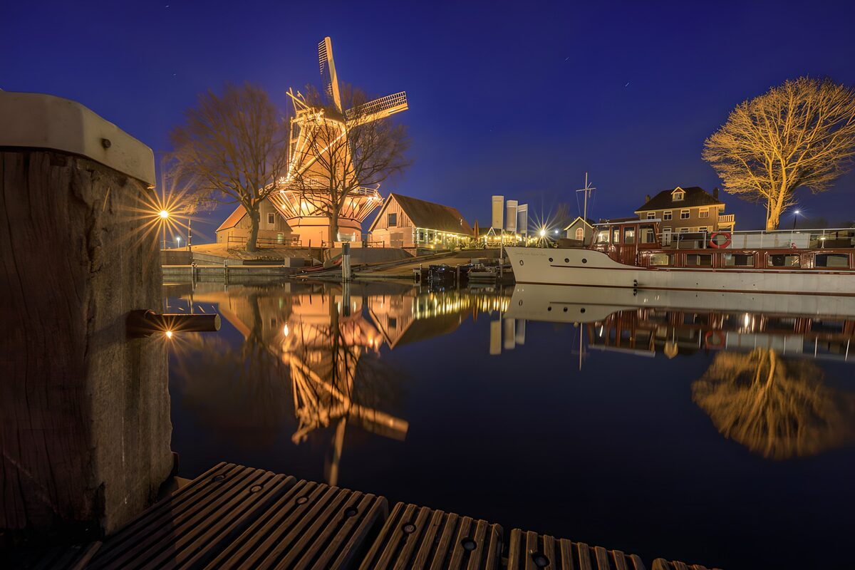 Verlichte molen bij de waterkant